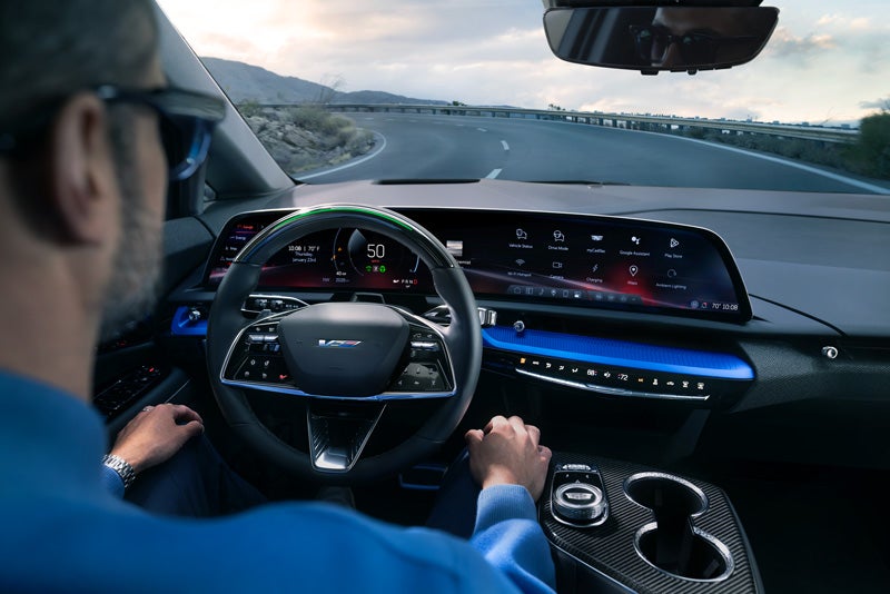 Front View of the 2026 OPTIQ-V Driving Through the Dusk Utilizing its Headlights | Dutton Cadillac in RIVERSIDE CA