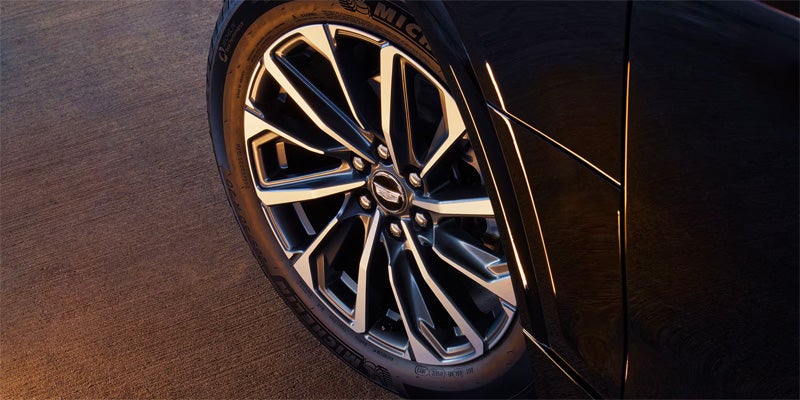 Close-up of a Cadillac car wheel with a black and polished silver multi-spoke rim and a Michelin tire.